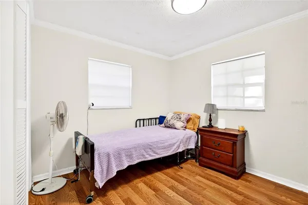a bedroom with a bed and wooden floor