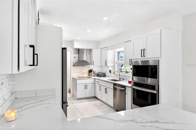 a kitchen with stainless steel appliances a stove a sink and a refrigerator