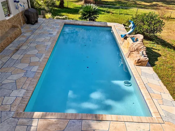 a view of a house with pool and sitting area
