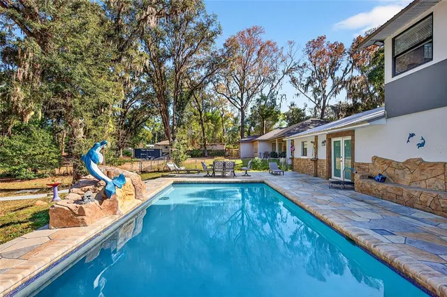 a view of a house with pool and sitting area