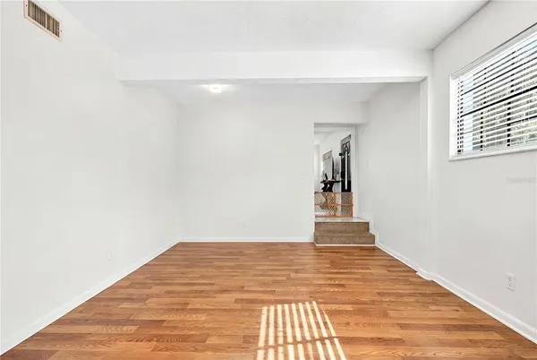 a view of a hallway with wooden floor and a window