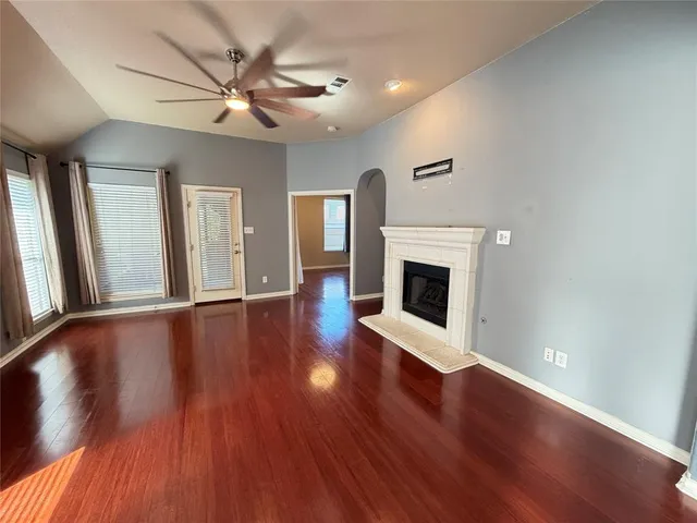 a view of a livingroom with wooden floor and a ceiling fan