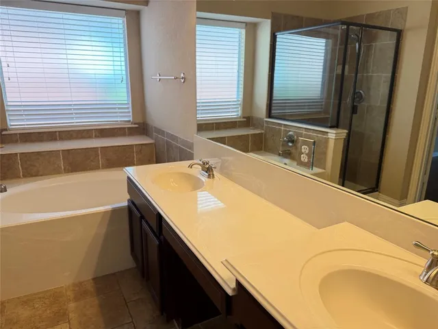 a bathroom with a granite countertop sink and a bathtub