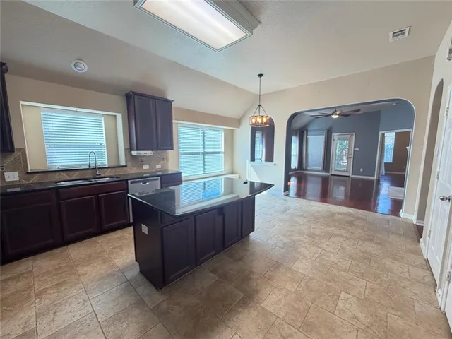 a kitchen with stainless steel appliances granite countertop a stove and a wooden cabinets