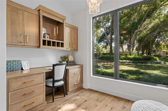 a room with a bed and large windows