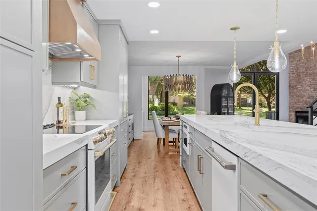a large kitchen with a lot of counter space and wooden floor