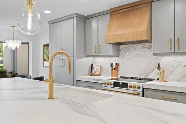 a kitchen with stainless steel appliances granite countertop a sink a stove and a refrigerator