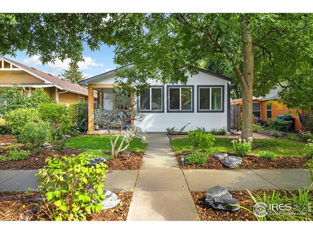 a front view of a house with a yard and potted plants