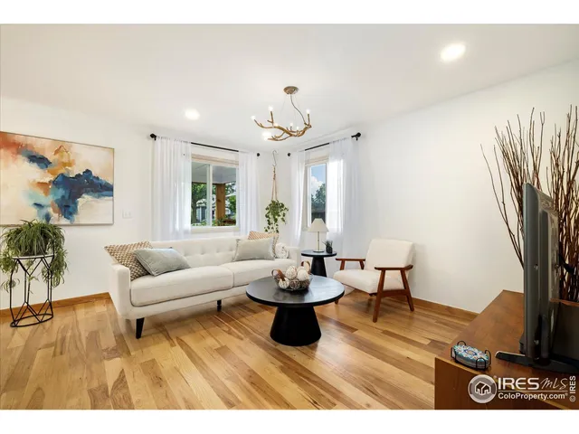 a living room with furniture a window and a flat screen tv