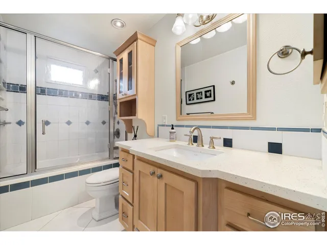 a bathroom with a granite countertop sink a mirror and a shower