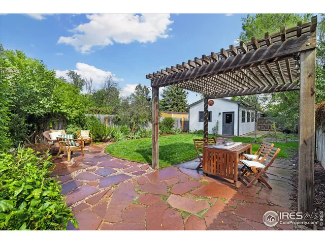 a view of a backyard with table and chairs with wooden fence