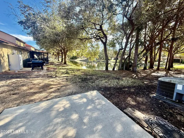 a view of a backyard with table and chairs under an umbrella
