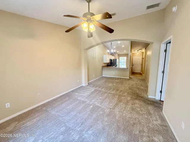 a view of a hallway with a chandelier fan and a large window