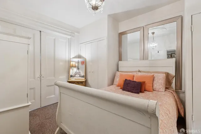 a bedroom with a large bed and a chandelier