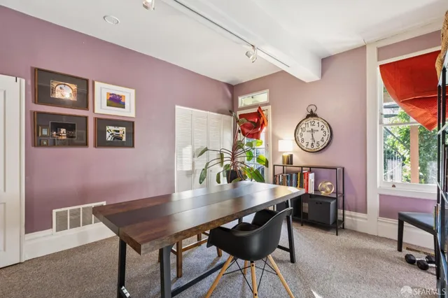 a living room with a table chairs and a book shelf
