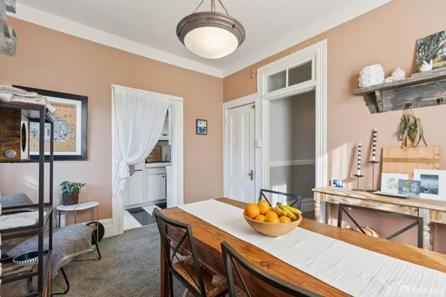 a balcony with table and chairs and potted plants