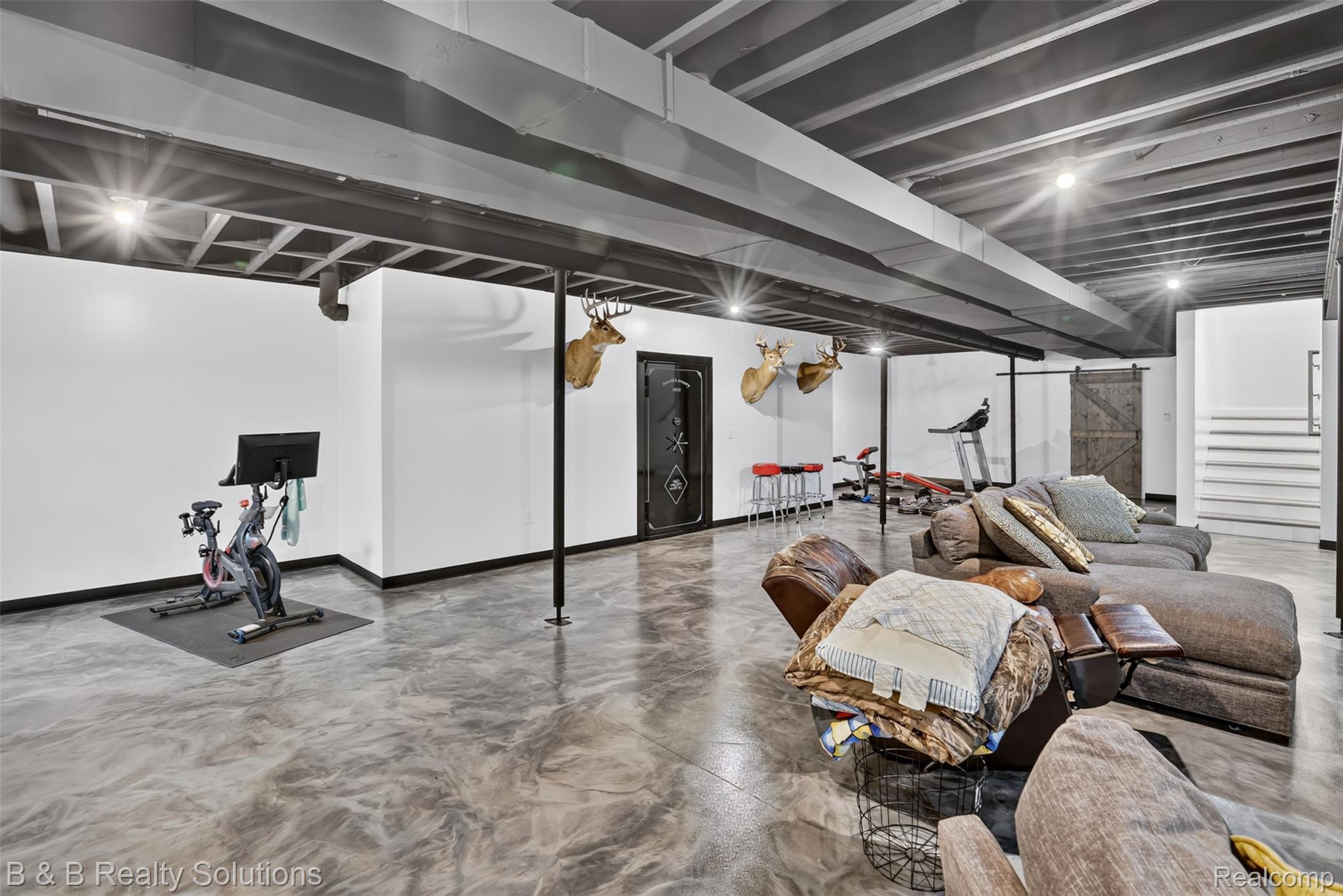 6204 Fish Lake Road North Branch, MI 48461 - Photo 45 of 79 Spacious lower level featuring exposed black joists with recessed lighting, white walls, and a distinctive metallic epoxy floor