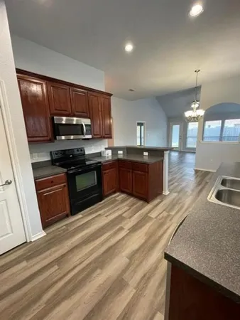 a large kitchen with stainless steel appliances granite countertop a stove a sink dishwasher and a refrigerator