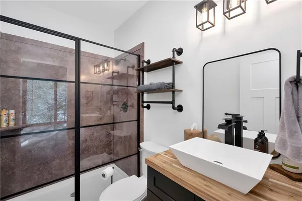 a bathroom with a sink mirror and a shower