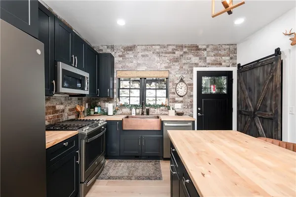 a kitchen with stainless steel appliances granite countertop wooden cabinets a stove top oven a sink and dishwasher