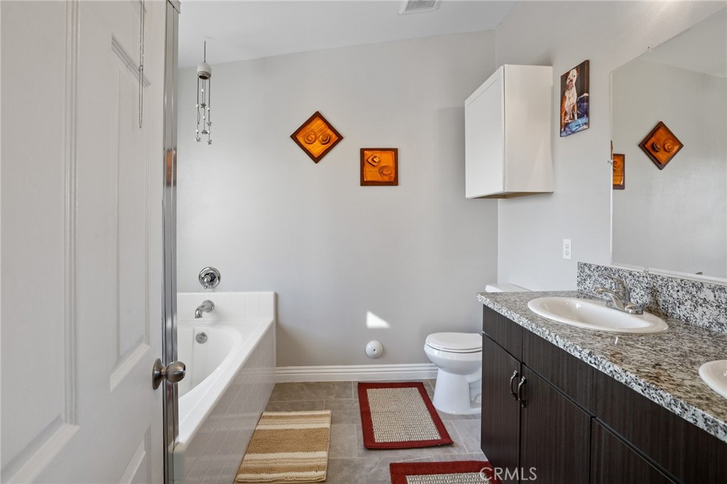 7755 7th Street Phelan, CA 92371 - Photo 26 of 27 a bathroom with a granite countertop sink and a mirror