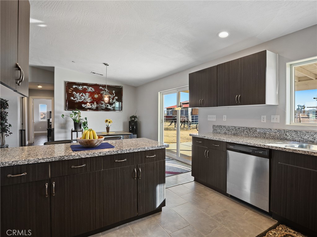 7755 7th Street Phelan, CA 92371 - Photo 7 of 27 a kitchen with stainless steel appliances granite countertop a sink and a stove