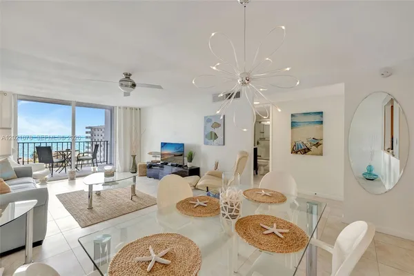 a living room with furniture kitchen view and a large window