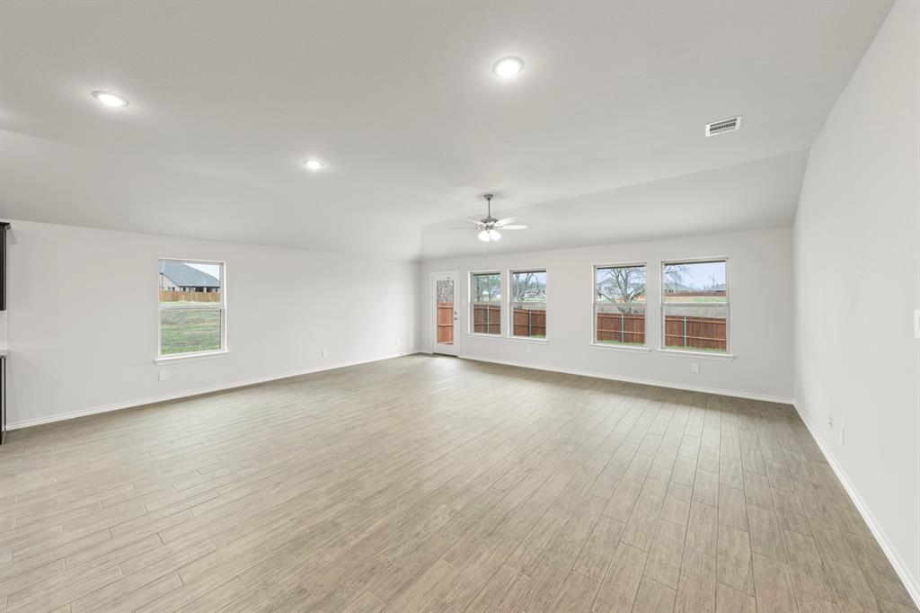 1120 Rushing Court Aubrey, TX 76227 - Photo 11 of 27 an empty room with wooden floor and windows