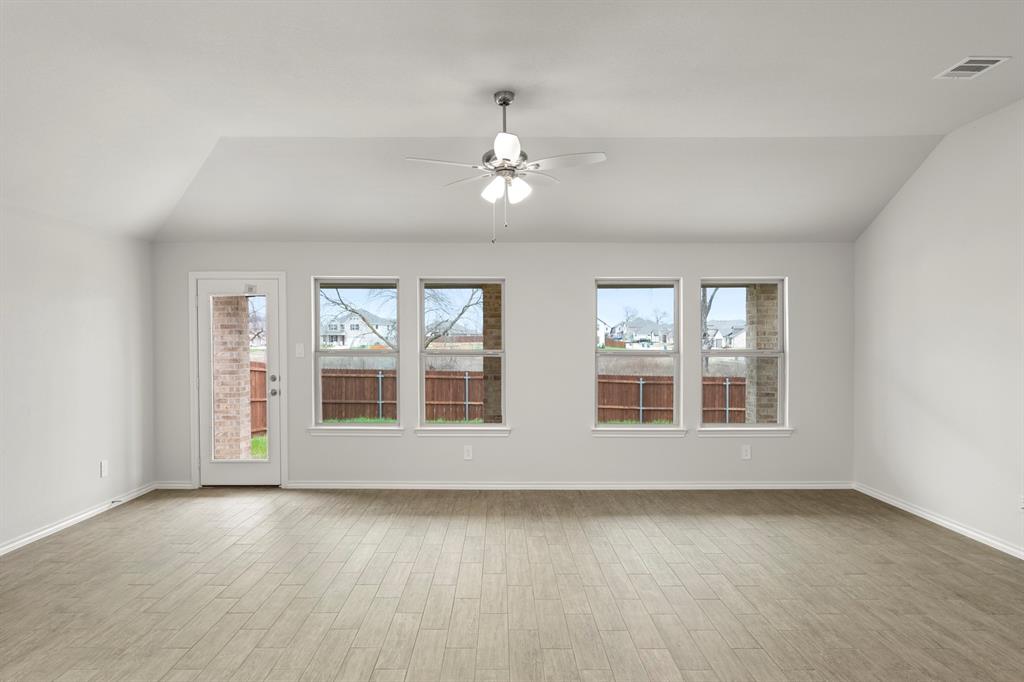 1120 Rushing Court Aubrey, TX 76227 - Photo 12 of 27 an empty room with wooden floor and windows