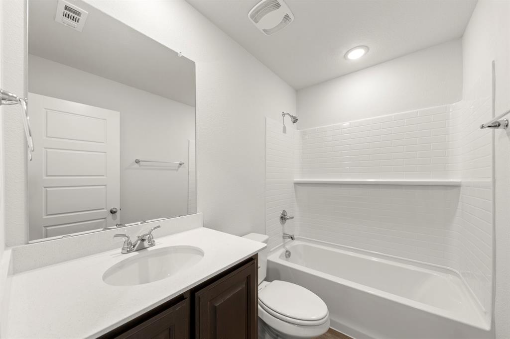 1120 Rushing Court Aubrey, TX 76227 - Photo 17 of 27 a bathroom with a bathtub shower sink vanity mirror and toilet