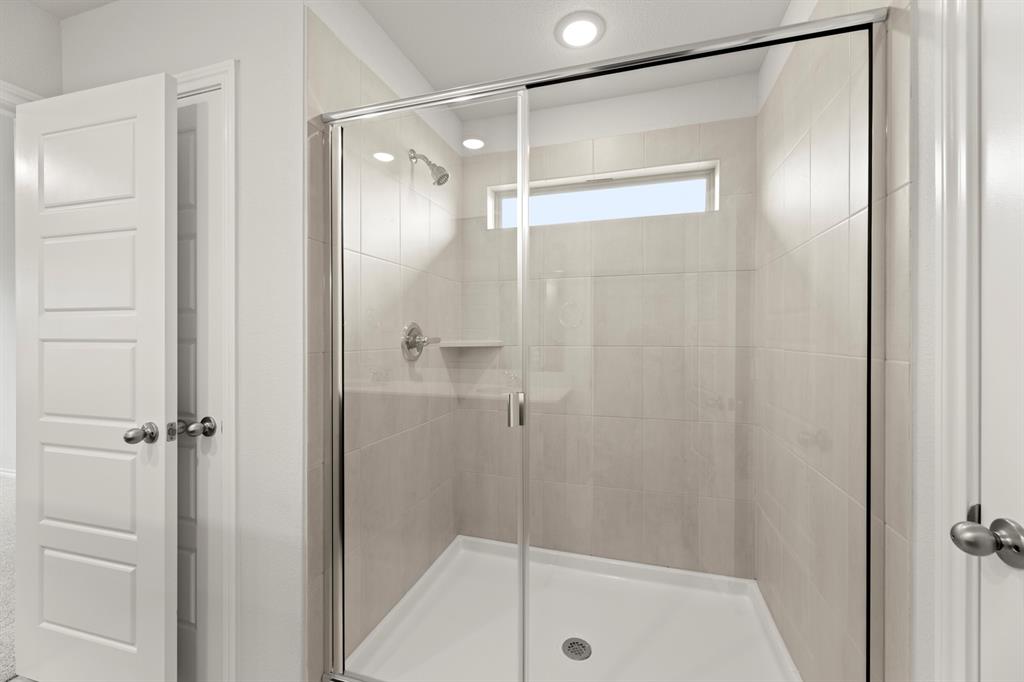 1120 Rushing Court Aubrey, TX 76227 - Photo 23 of 27 a bathroom with a glass shower door