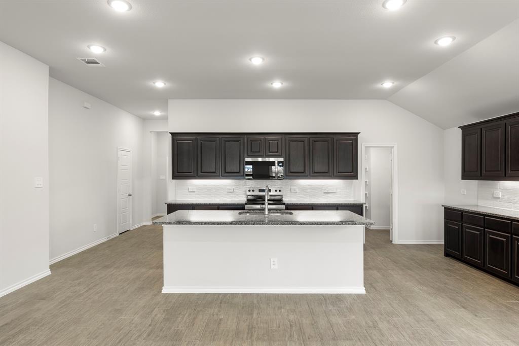 1120 Rushing Court Aubrey, TX 76227 - Photo 4 of 27 a view of kitchen with kitchen island stainless steel appliances a sink and stove