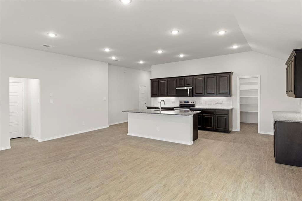 1120 Rushing Court Aubrey, TX 76227 - Photo 8 of 27 a large kitchen with kitchen island a sink dishwasher a stove and a refrigerator with wooden floor