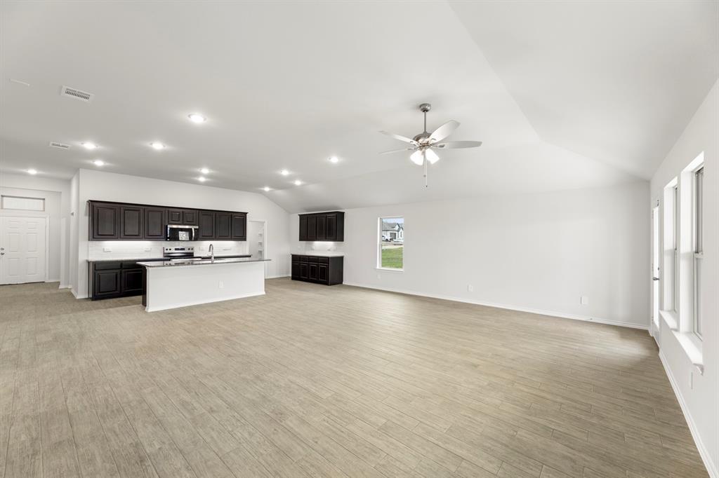 1120 Rushing Court Aubrey, TX 76227 - Photo 9 of 27 a view of kitchen with kitchen island a sink and a stove with wooden floor