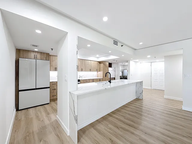 a view of a kitchen with wooden floor and a window