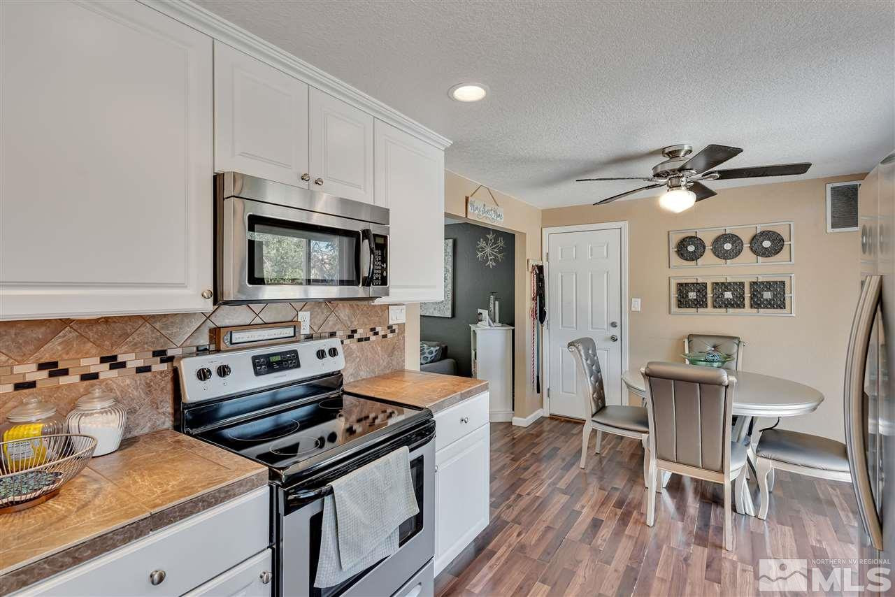32 Gault Way Sparks, NV 89431 - Photo 11 of 26 a kitchen with stainless steel appliances a stove a sink dishwasher and a refrigerator with wooden floor