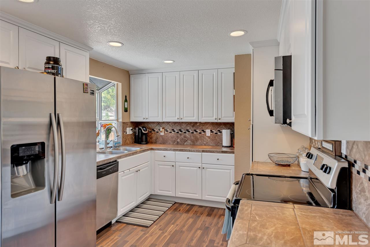 32 Gault Way Sparks, NV 89431 - Photo 8 of 26 a kitchen with white cabinets and refrigerator