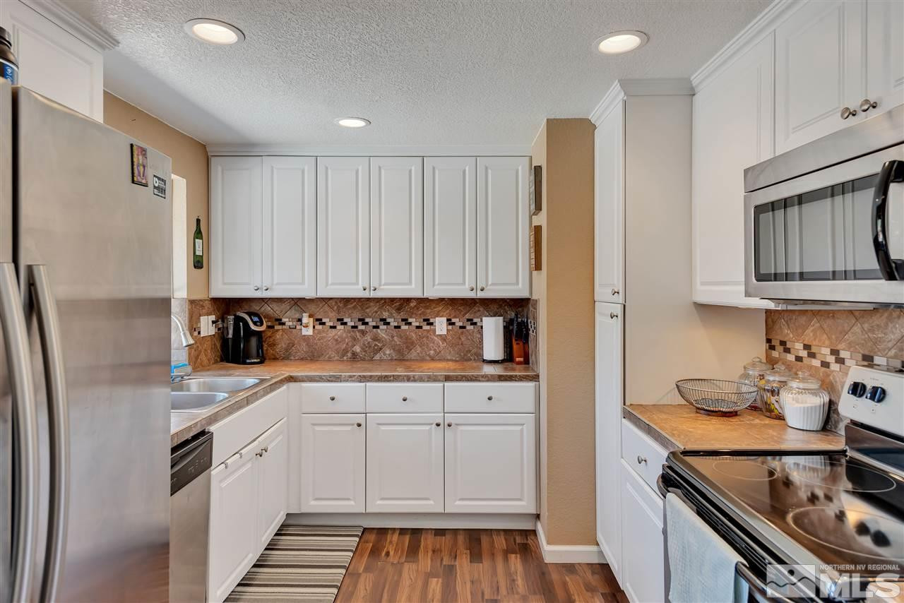 32 Gault Way Sparks, NV 89431 - Photo 9 of 26 a kitchen with stainless steel appliances granite countertop a refrigerator and a stove top oven