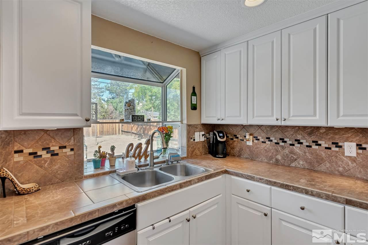 32 Gault Way Sparks, NV 89431 - Photo 10 of 26 a kitchen with granite countertop a sink a stove and cabinets