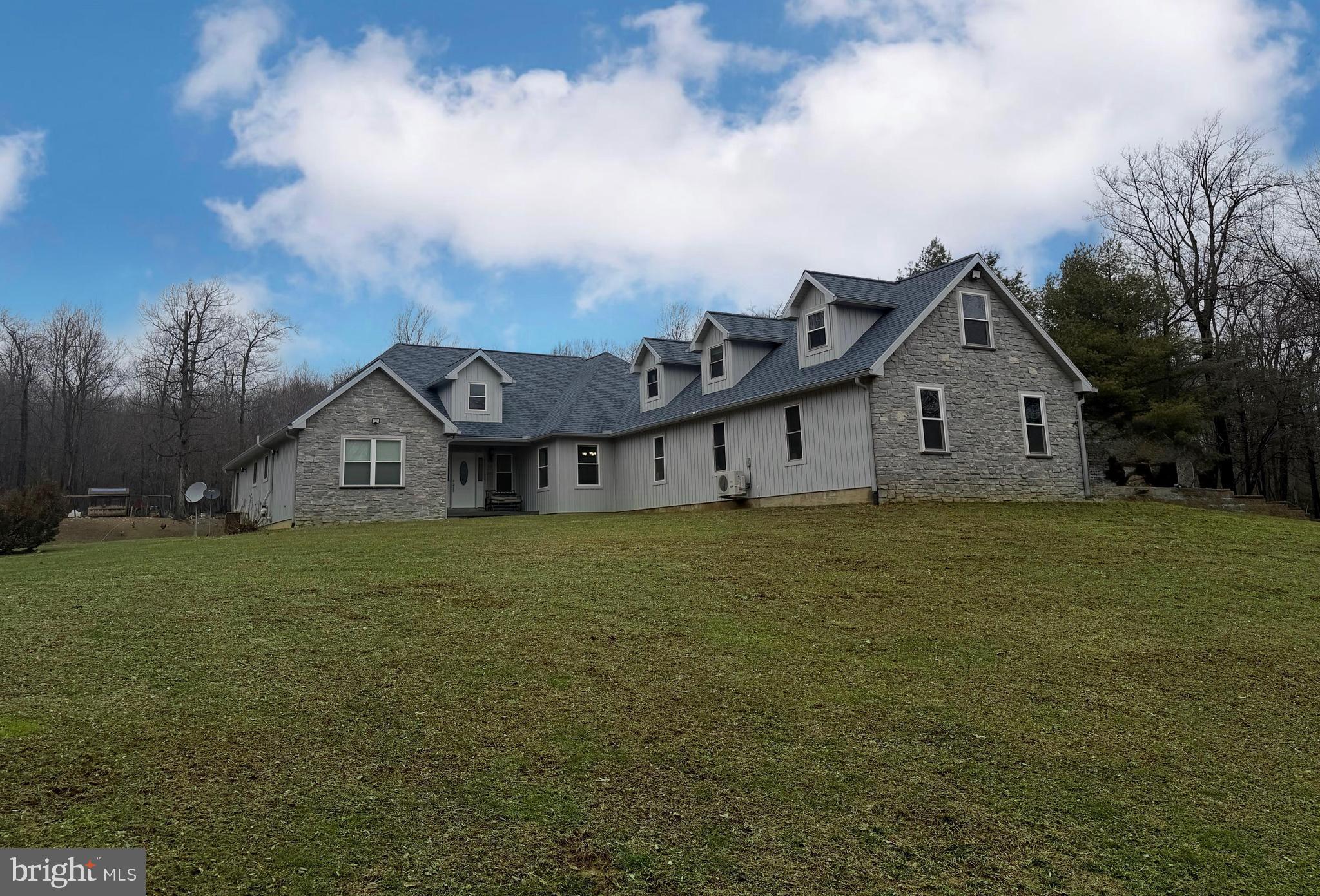 a view of a house with a big yard and large trees