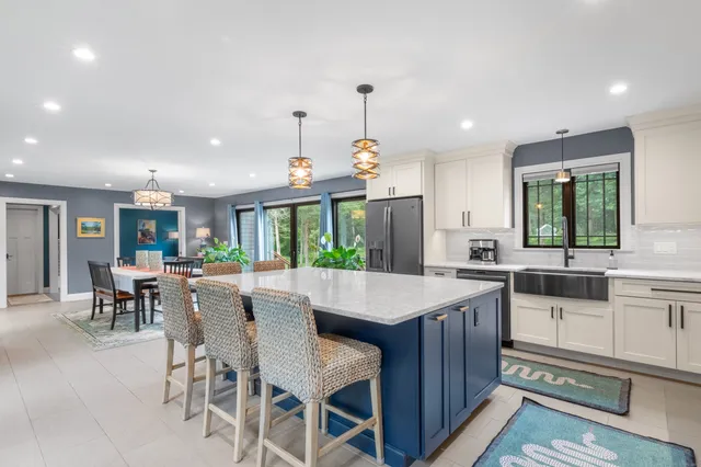 a kitchen with a dining table chairs stainless steel appliances and cabinets