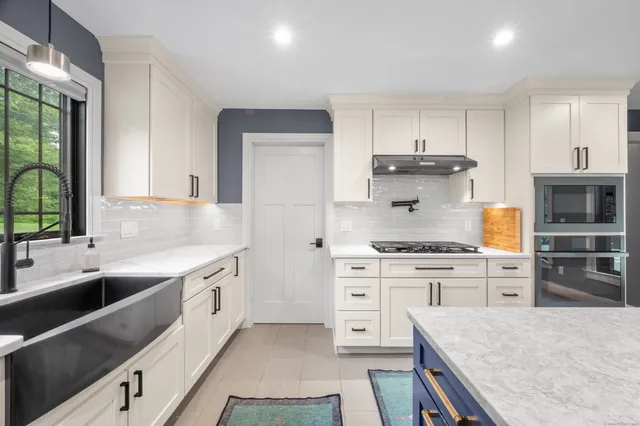 a kitchen with stainless steel appliances granite countertop a stove a sink and a refrigerator