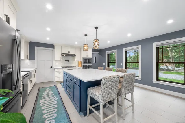a kitchen with stainless steel appliances granite countertop a sink and a refrigerator
