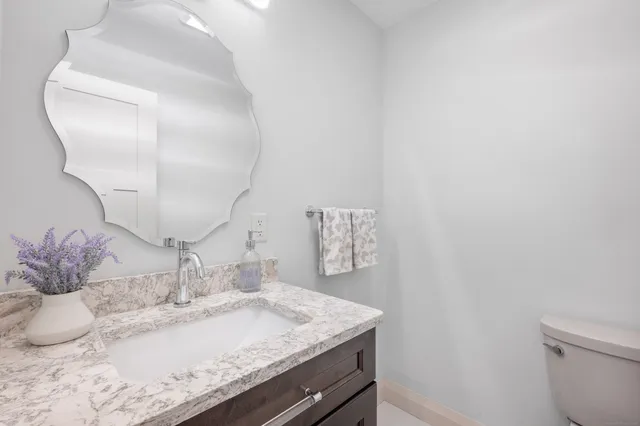 a bathroom with a granite countertop sink and a mirror