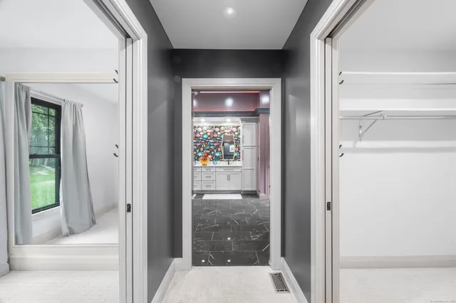 a view of a hallway with wooden floor and a living room