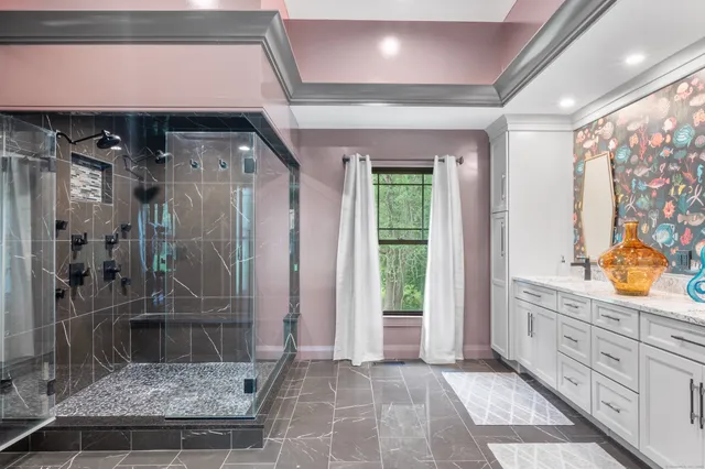 a bathroom with a granite countertop sink a toilet and shower