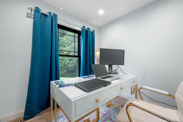 a view of a workspace with furniture and a window