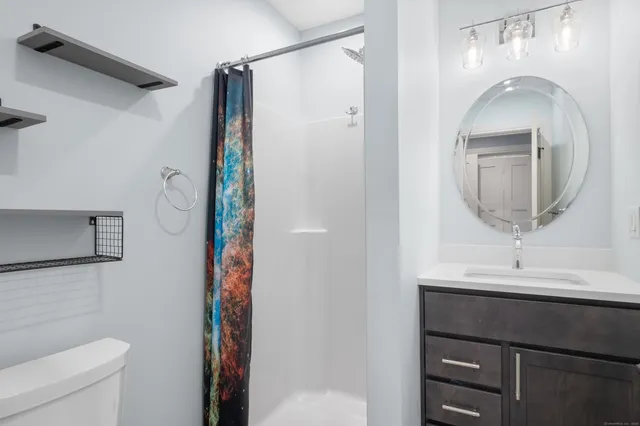 a bathroom with a sink a toilet and shower