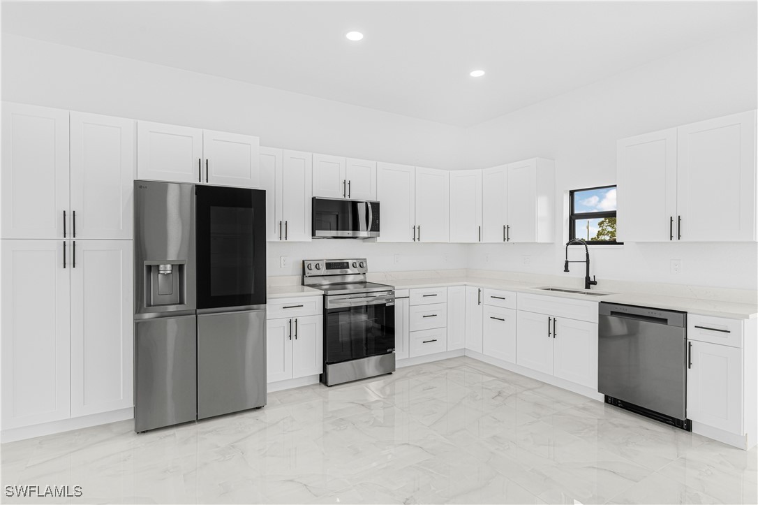 9007 East Crow Circle LaBelle, FL 33935 - Photo 22 of 46 a kitchen with granite countertop white cabinets and stainless steel appliances
