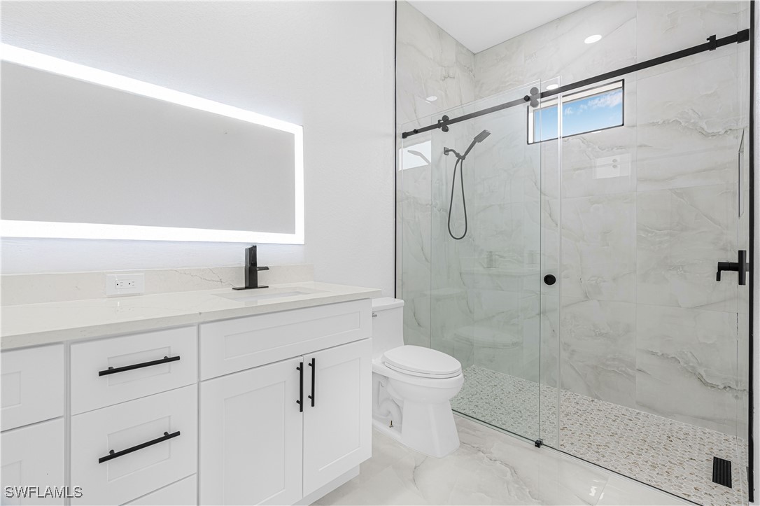 9007 East Crow Circle LaBelle, FL 33935 - Photo 28 of 46 a bathroom with a shower sink vanity mirror and toilet